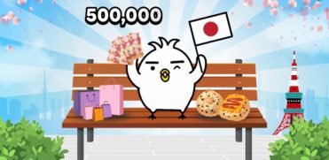 Bird Tori in the bench in front of Tokyo Tower holding a Japan Flag and surrounded by Japanese food and shopping bags