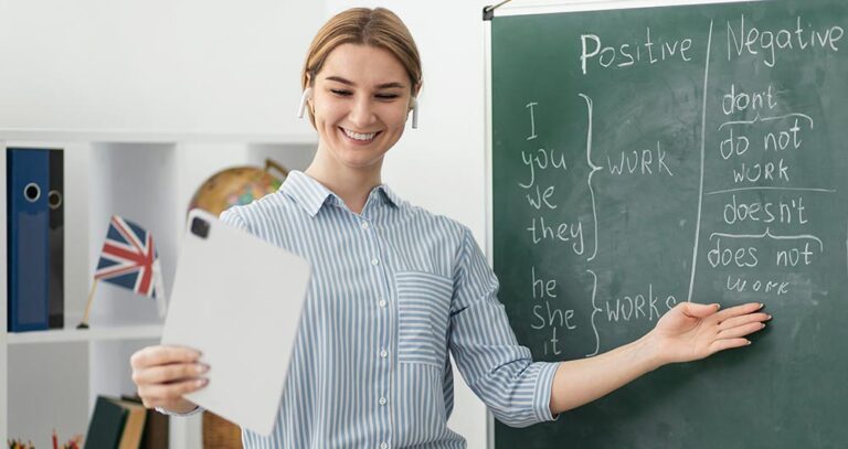 Guru Bahasa Inggris sedang mengajar dan menunjuk papan