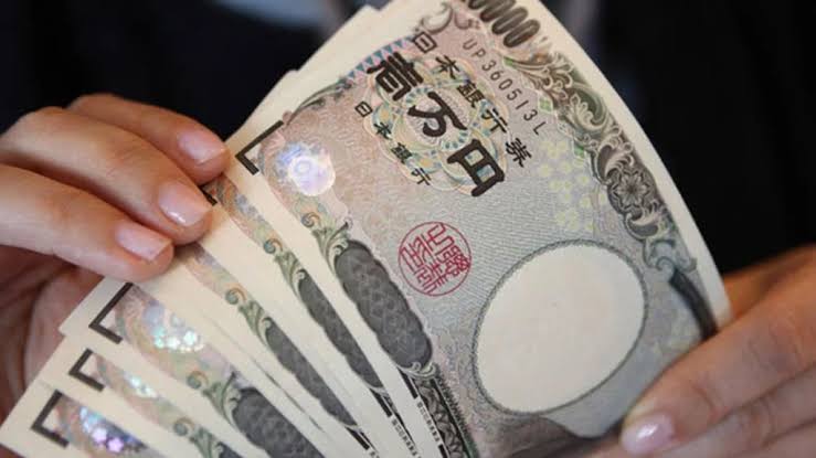 Orang memegang banyak uang JPY 10.000