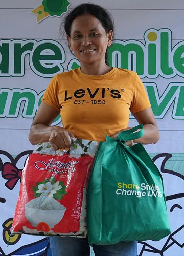 One Million Smiles 2026. A student's mother holding her One Million Smiles package and a pack of rice