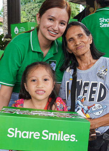 One Million Smiles 2026. A student with his relative showing the "ShareSmiles." package