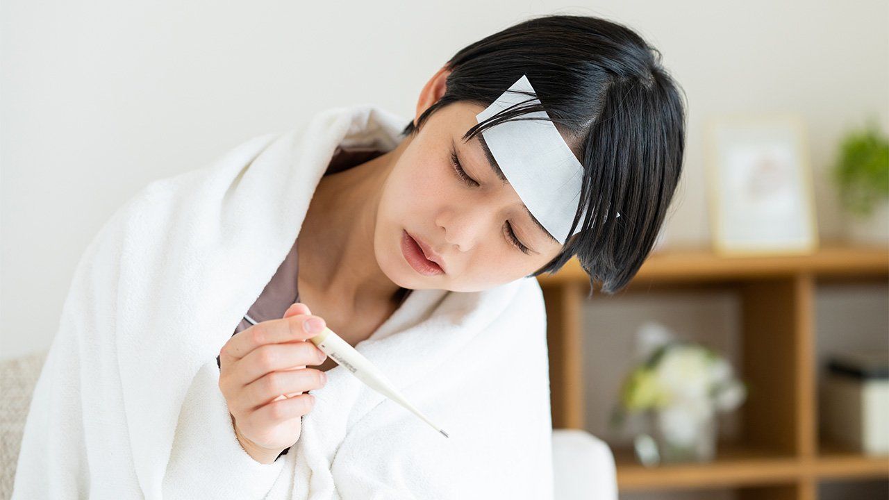 Orang terkena flu, mengecek demam