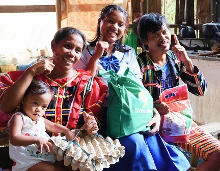 Family of four posing with egg crates and 'share smiles' bag.