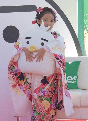 a girl holds smiles' mascot Tori