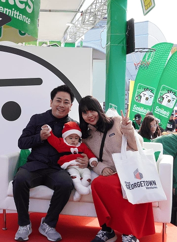 A family poses on the smiles remittance booth